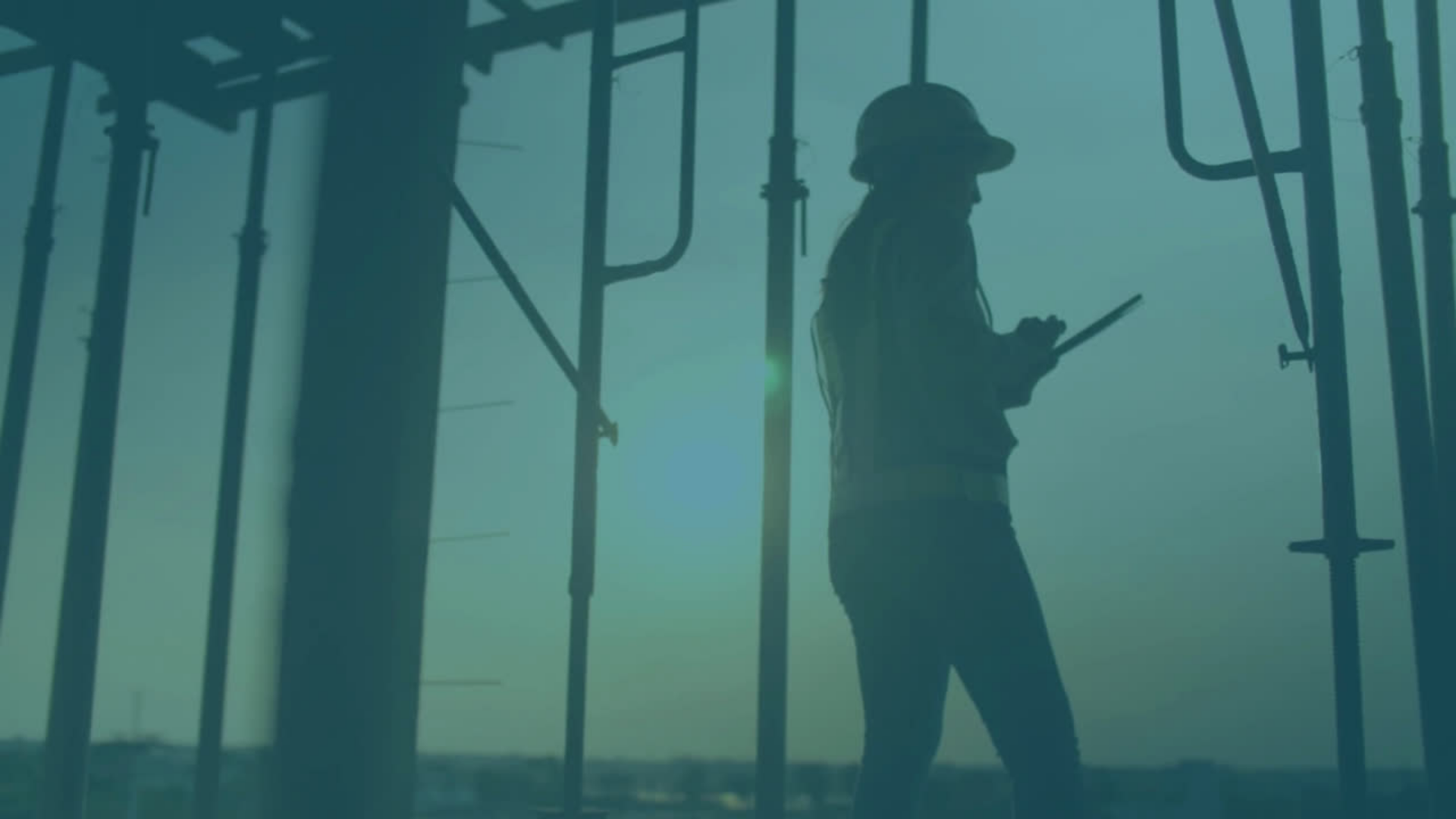 En kvinnlig projektarbetare med varselväst och hjälm står och antecknar i ett block